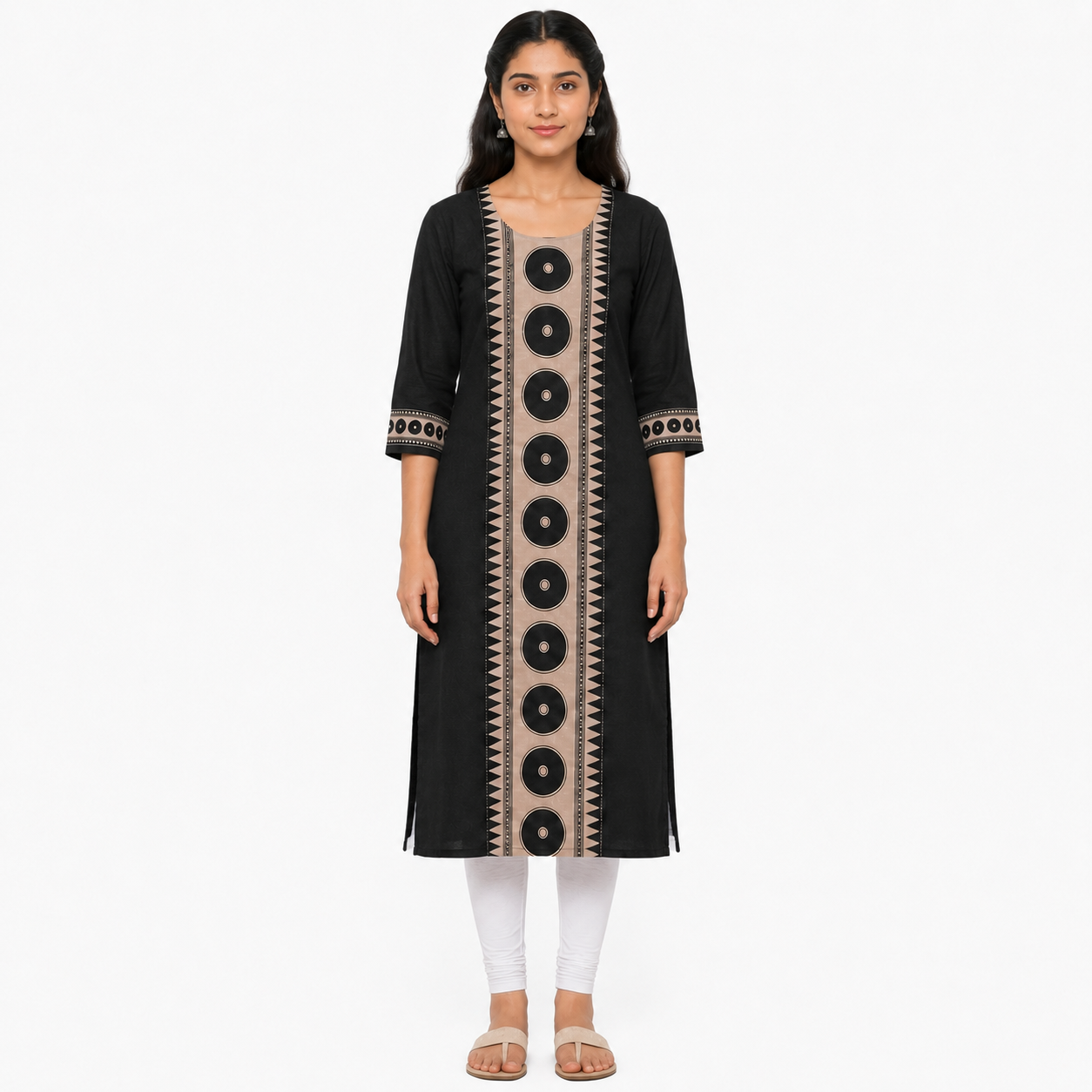 A woman modeling a black three-quarter sleeve kurta with beige vertical panels and circular black motifs, paired with white leggings and beige sandals, against a plain white background.