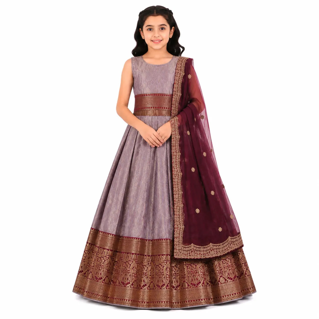A young girl modeling a traditional Indian ethnic outfit consisting of a lavender-gray sleeveless kurta, a matching flared skirt with ornate gold and maroon borders, and a deep maroon dupatta with gold motifs, set against a plain white background.