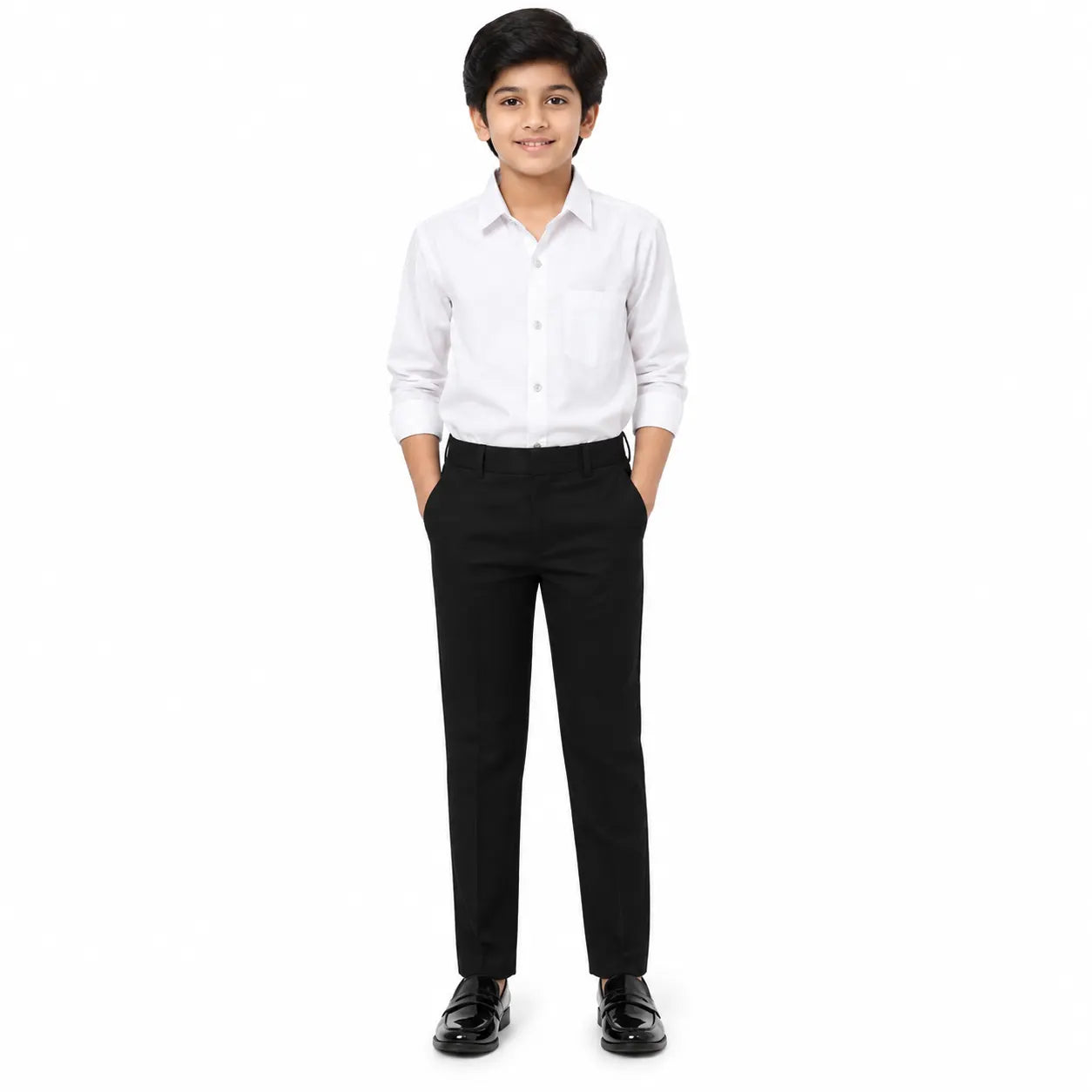 A young boy modeling a white long-sleeve button-down shirt and black trousers, standing against a solid white background.