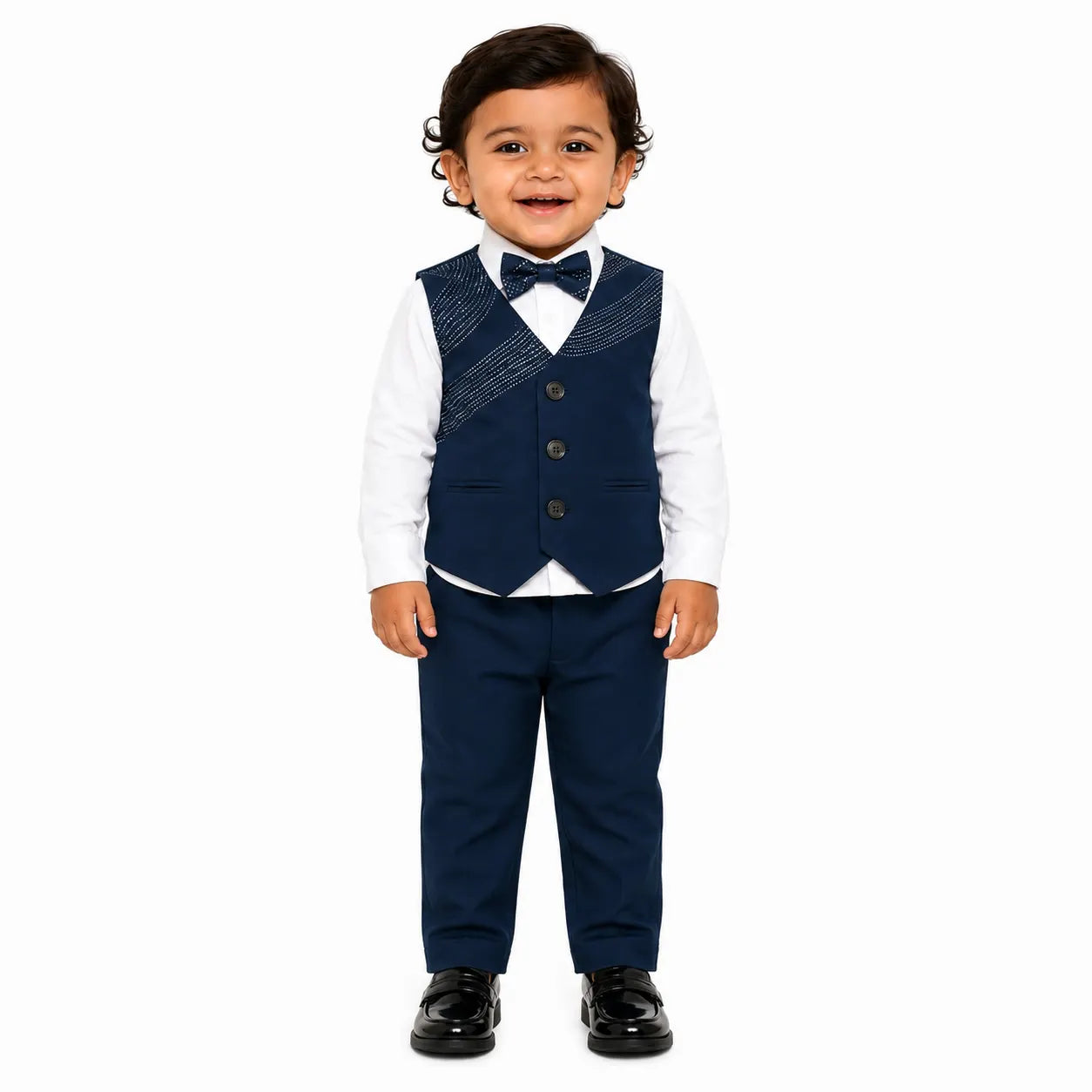 A toddler boy modeling a navy blue three-piece formal outfit consisting of a patterned vest, matching trousers, and a matching bow tie, worn over a white long-sleeve shirt and paired with black dress shoes, on a solid white background.