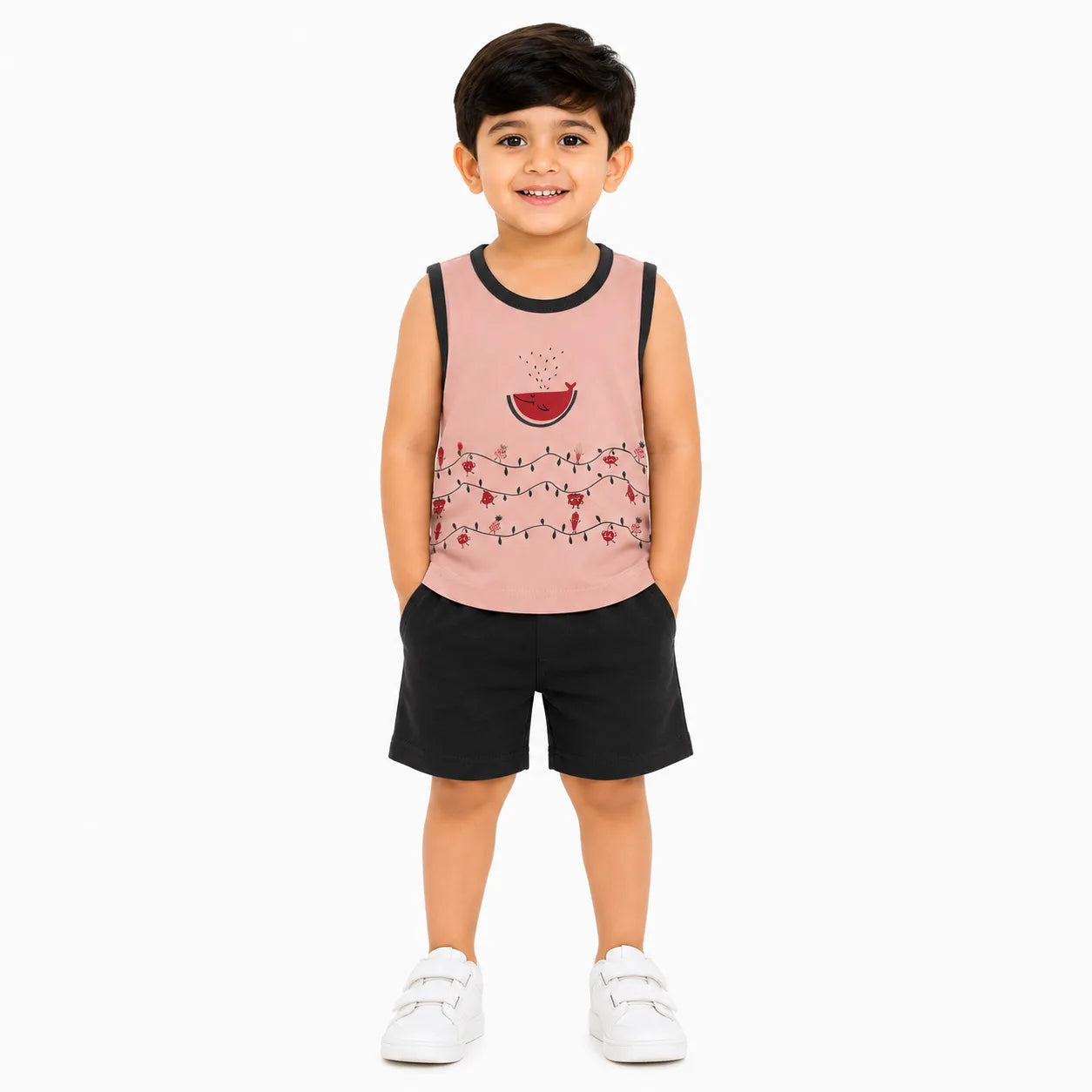A young boy modeling a sleeveless tank top and shorts set. The tank top is light pink with black trim, featuring a watermelon graphic and string lights pattern on the front.