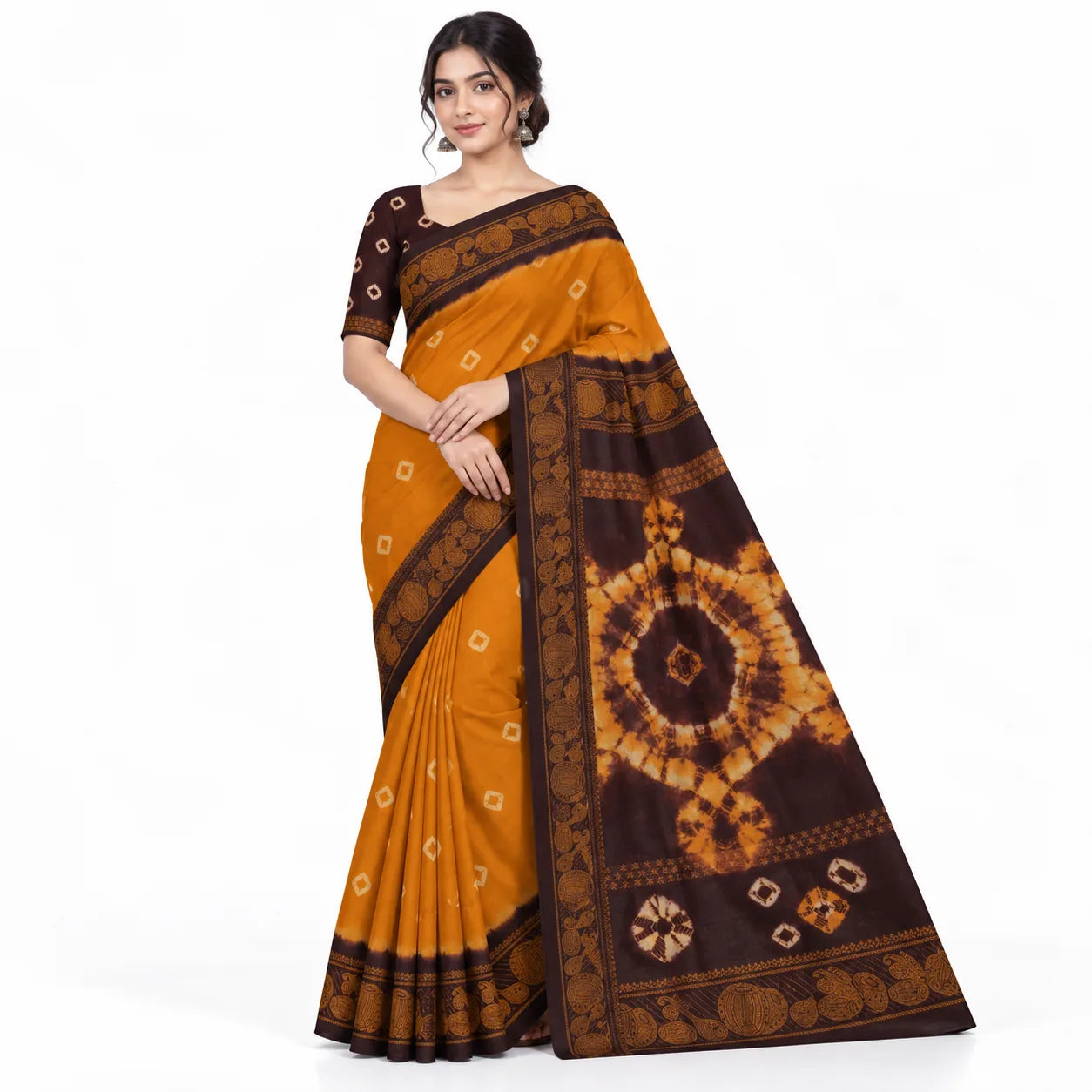 A woman modeling a mustard yellow and dark brown tie-dye saree with intricate geometric and circular patterns, set against a plain white background.