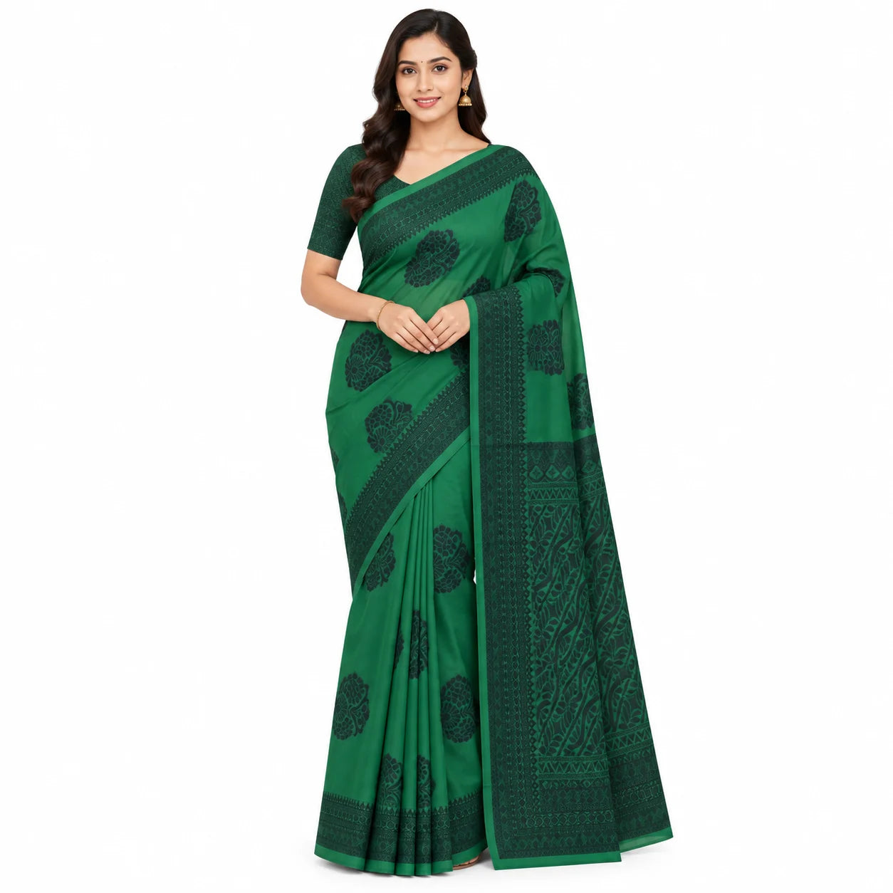 A woman modeling a green saree with dark green floral and geometric patterns, standing against a plain white background.