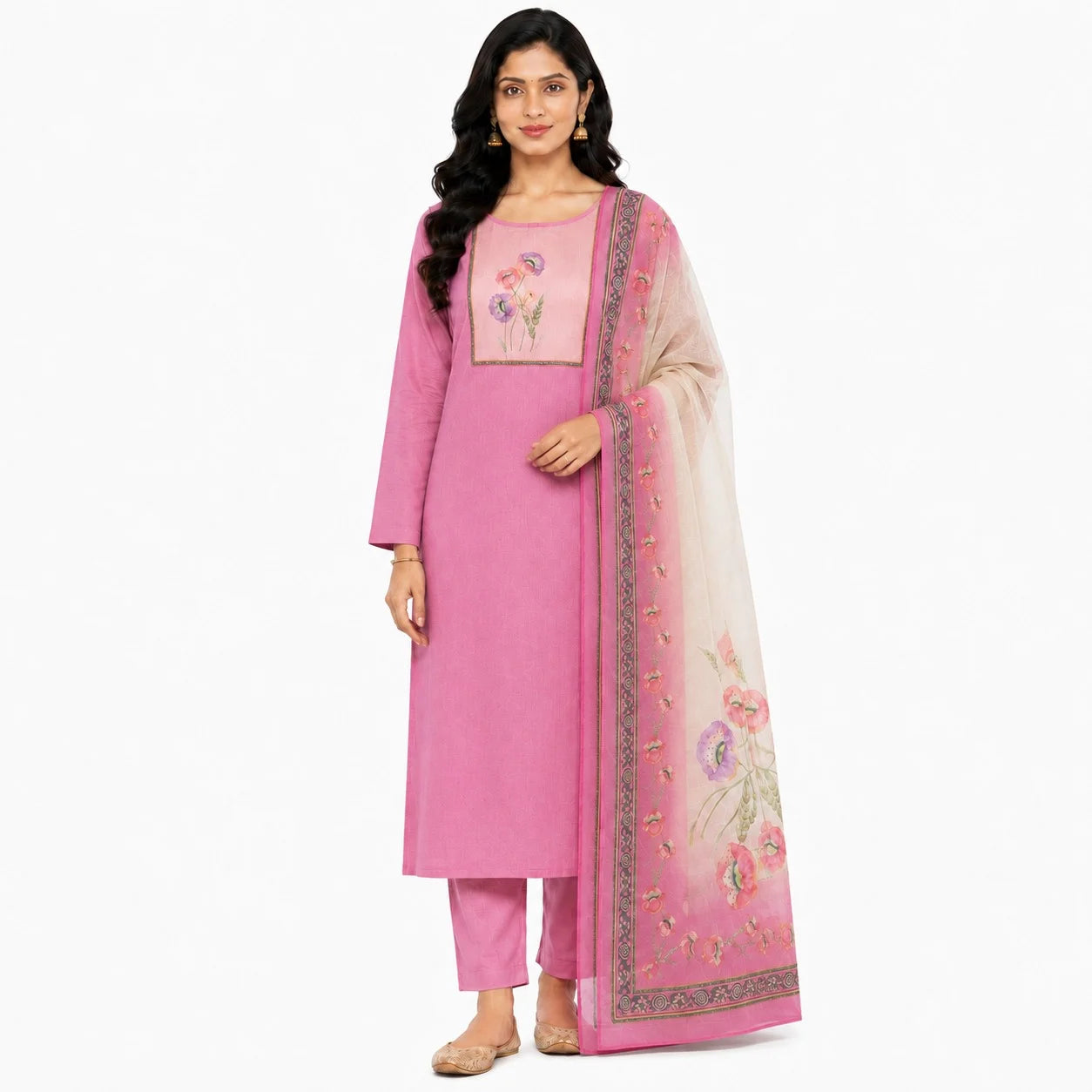 A woman modeling a pink traditional Indian salwar kameez set with matching pants and a sheer floral dupatta, photographed against a plain white studio background.