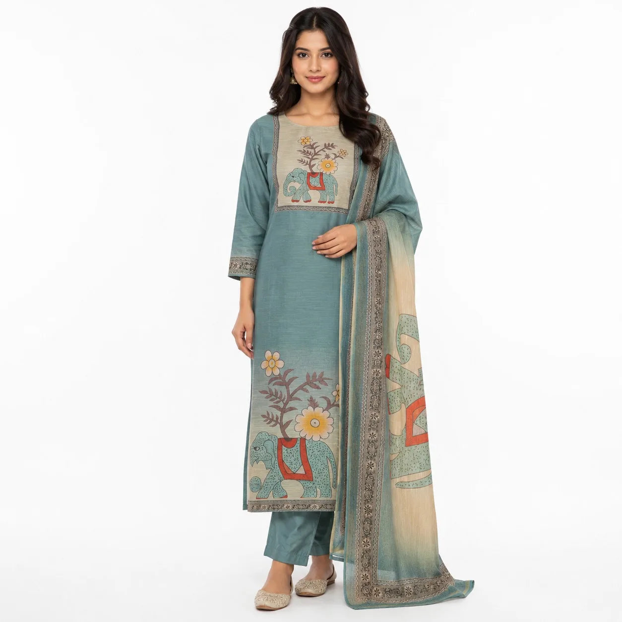 A woman modeling a traditional Indian salwar kameez suit in dusty teal, featuring an embroidered kameez top with elephant motifs, matching trousers, and a printed dupatta.