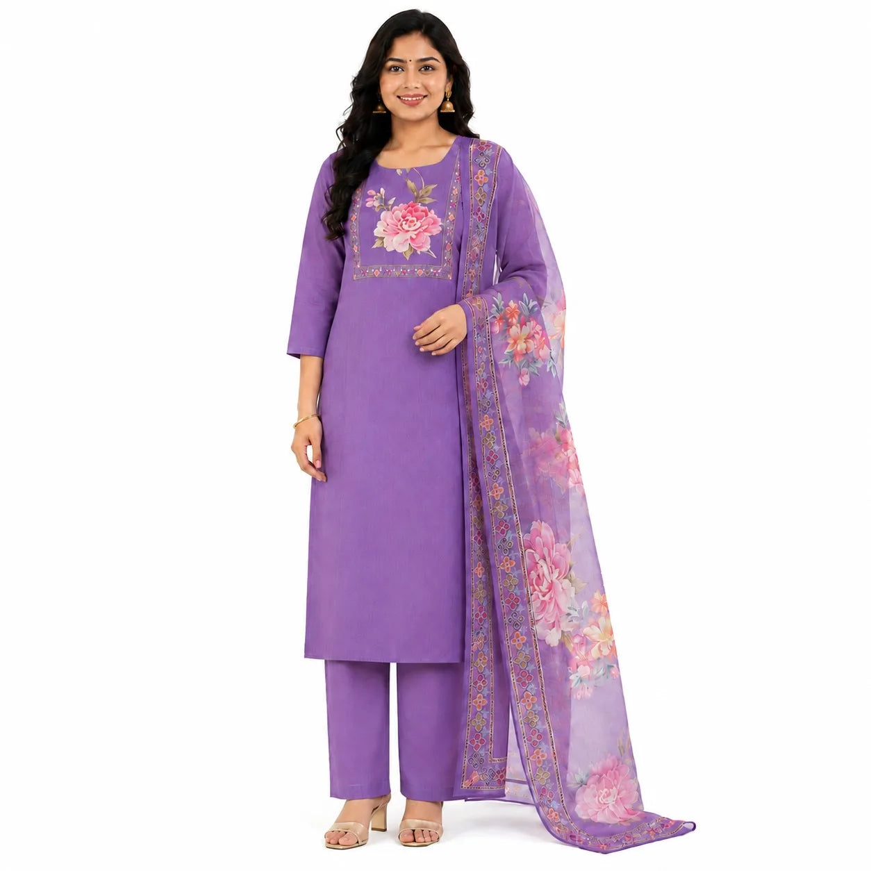 A woman modeling a purple salwar kameez suit with floral embroidery on the chest and a matching sheer floral dupatta, set against a plain white background.