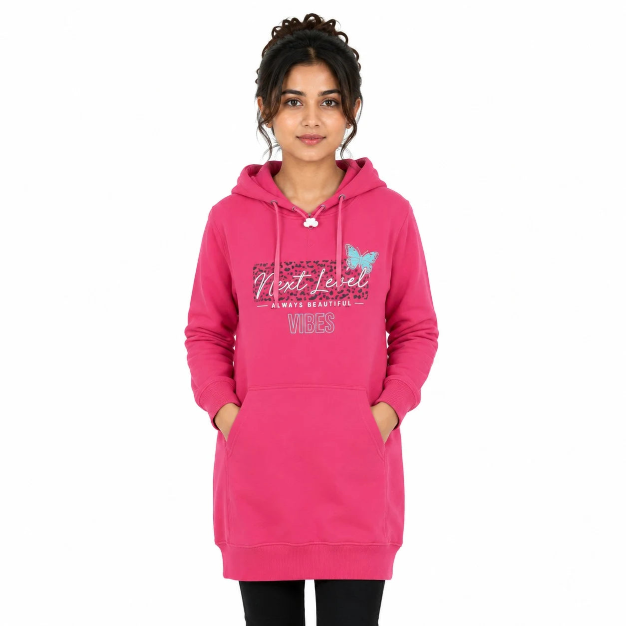 A woman modeling a bright pink hooded sweatshirt dress with a graphic on the front that reads 'Next Level NATURAL BEAUTY VIBES' alongside a butterfly design, set against a plain white background.