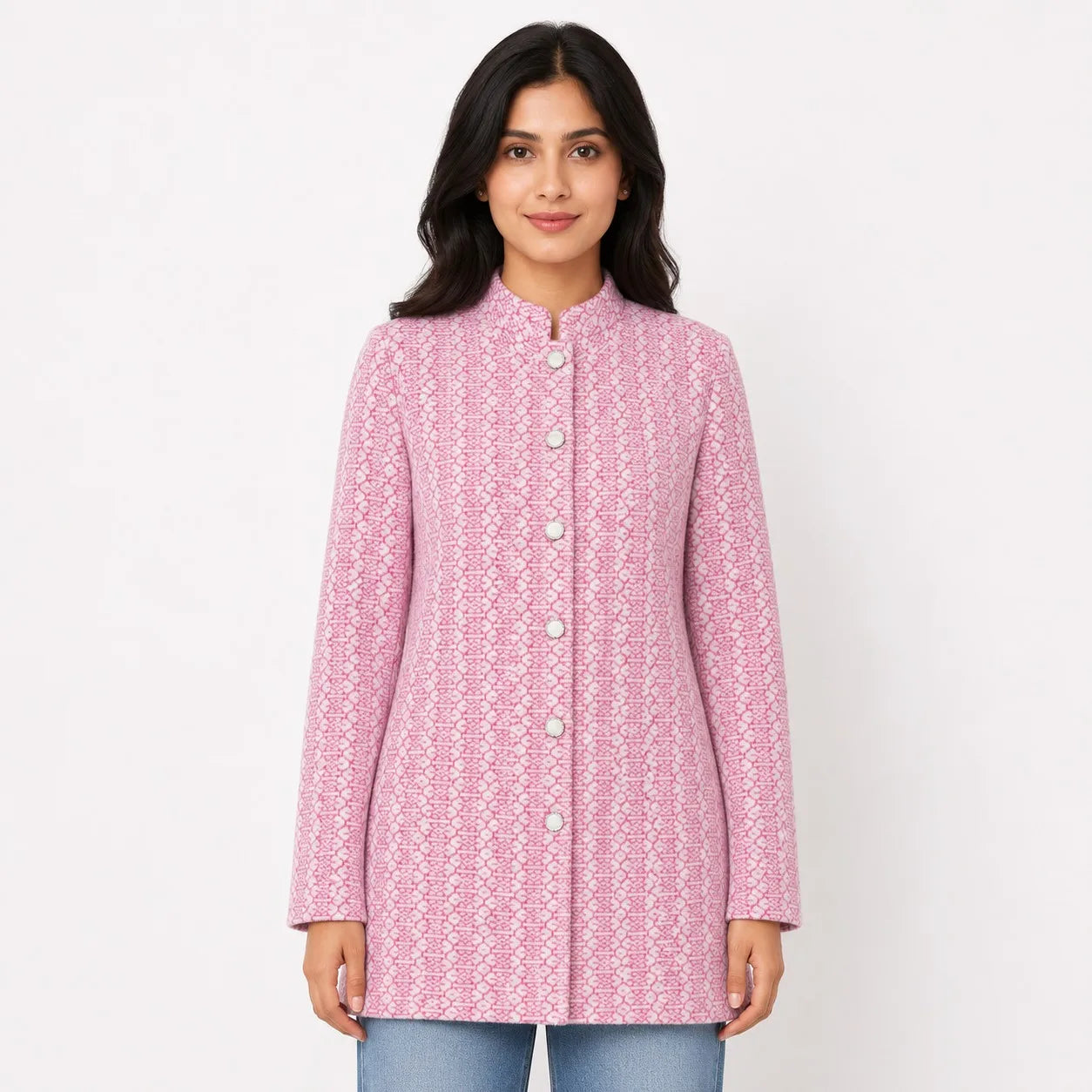 A woman modeling a pink and white patterned long-sleeve jacket with a mandarin collar and front buttons, paired with blue jeans, against a plain white background.