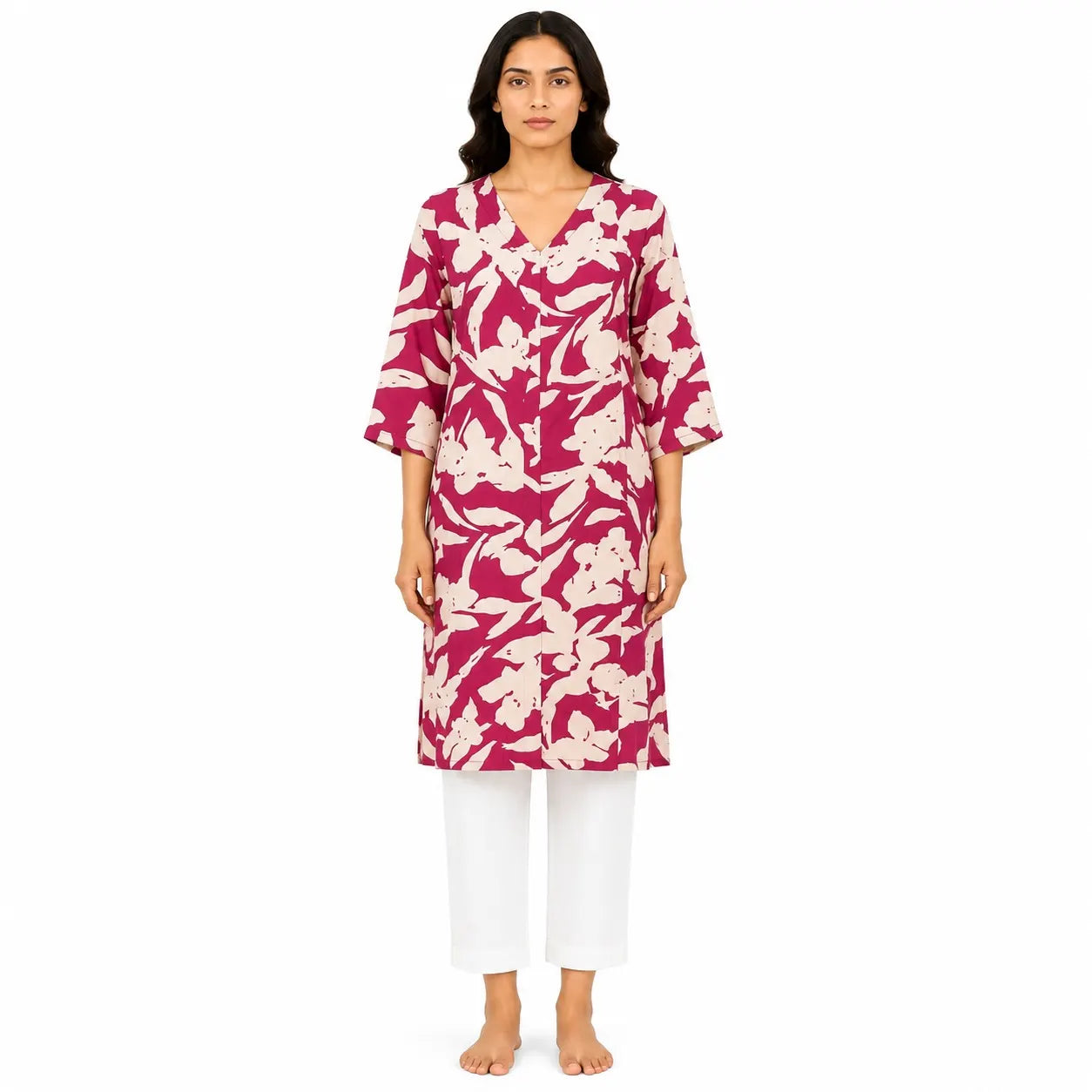 A woman modeling a magenta pink and cream floral print kurta with three-quarter sleeves, paired with white cropped pants, against a plain white background.
