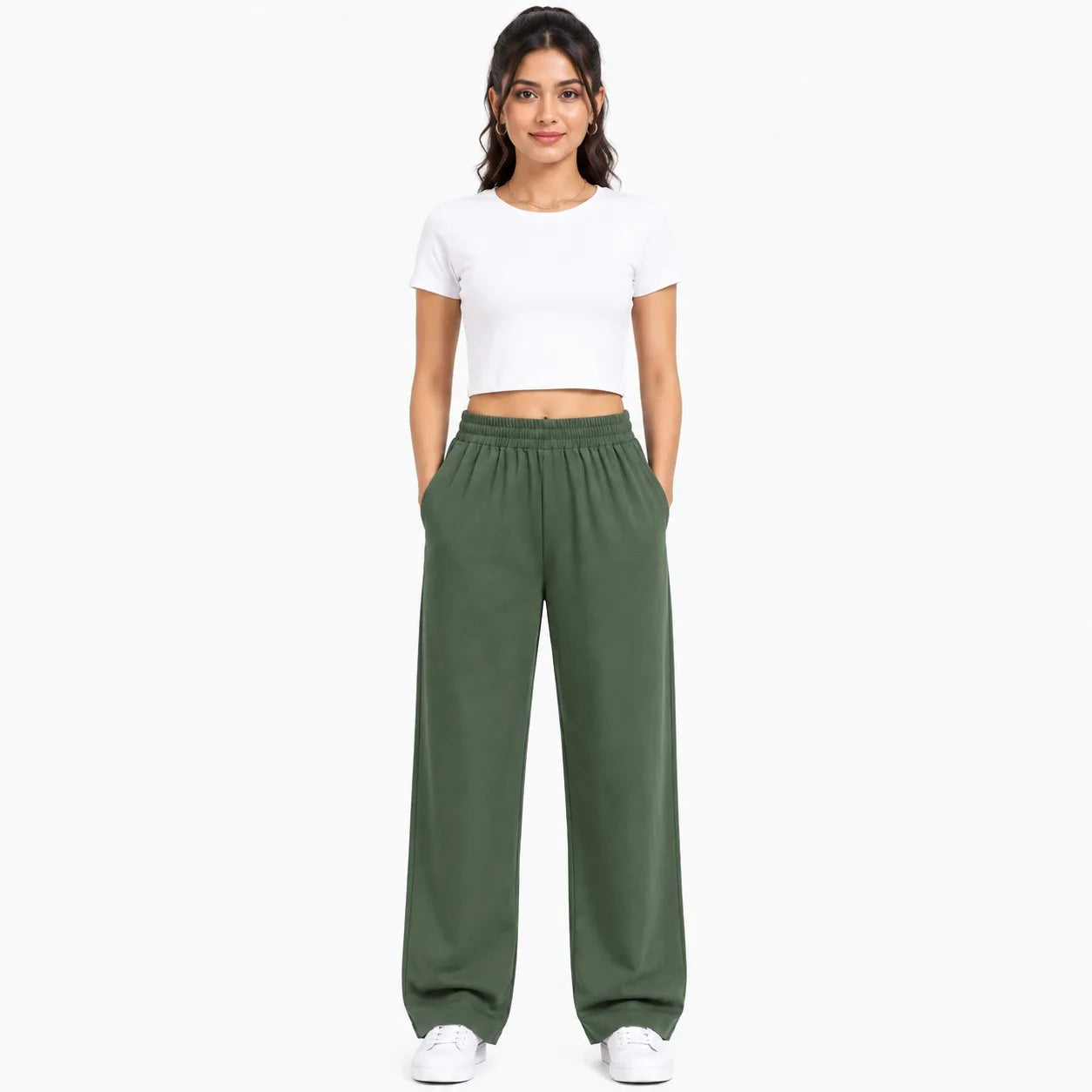 A woman modeling a white short-sleeve crop top and olive green wide-leg sweatpants against a plain white background.