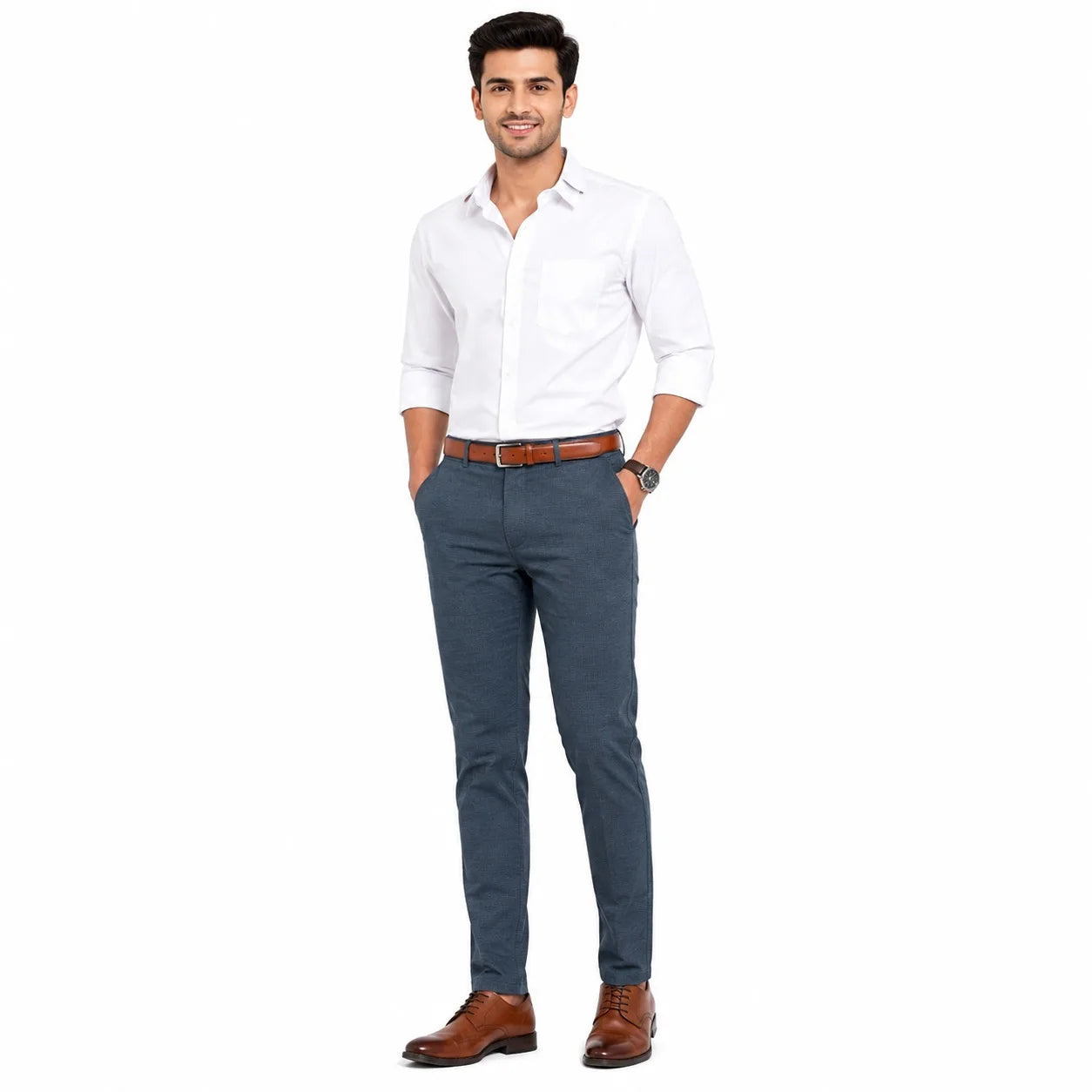 A man modeling a white long-sleeve button-down shirt, blue slim-fit trousers, a brown leather belt, and brown leather dress shoes against a plain white background.