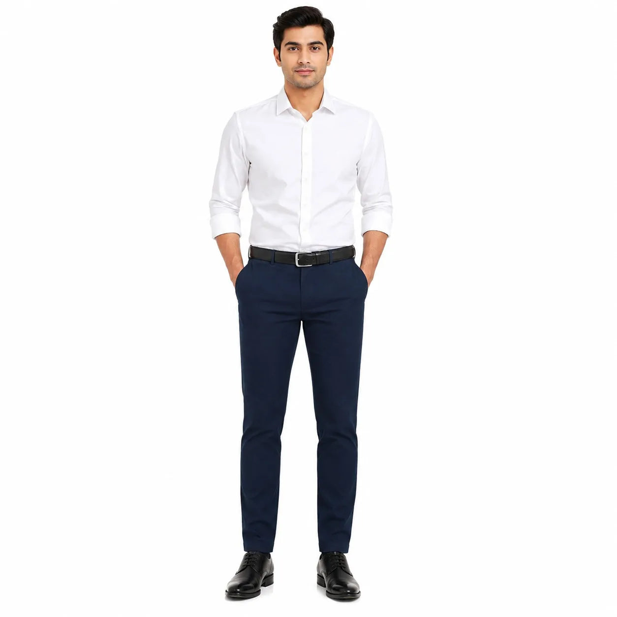 A man modeling a white long-sleeve button-down shirt and navy blue trousers with a black belt and black dress shoes, standing against a solid white background.