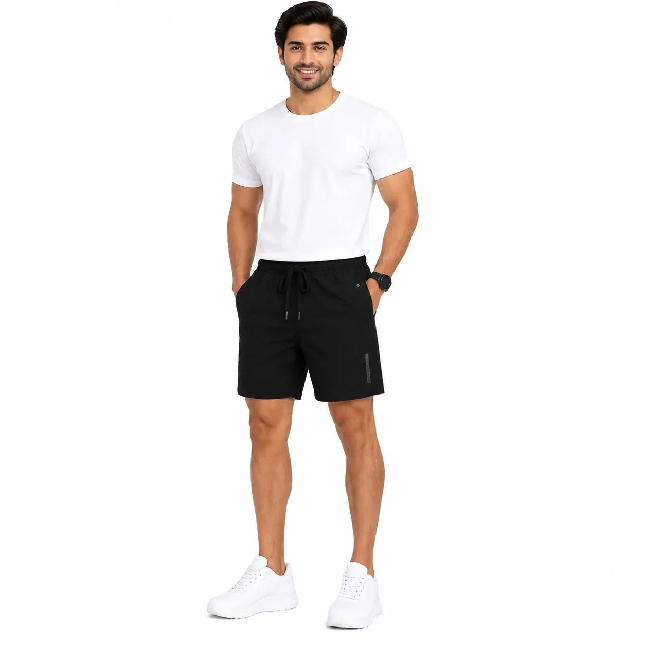 A man modeling black athletic drawstring shorts, paired with a white t-shirt and white sneakers, standing against a solid white background.