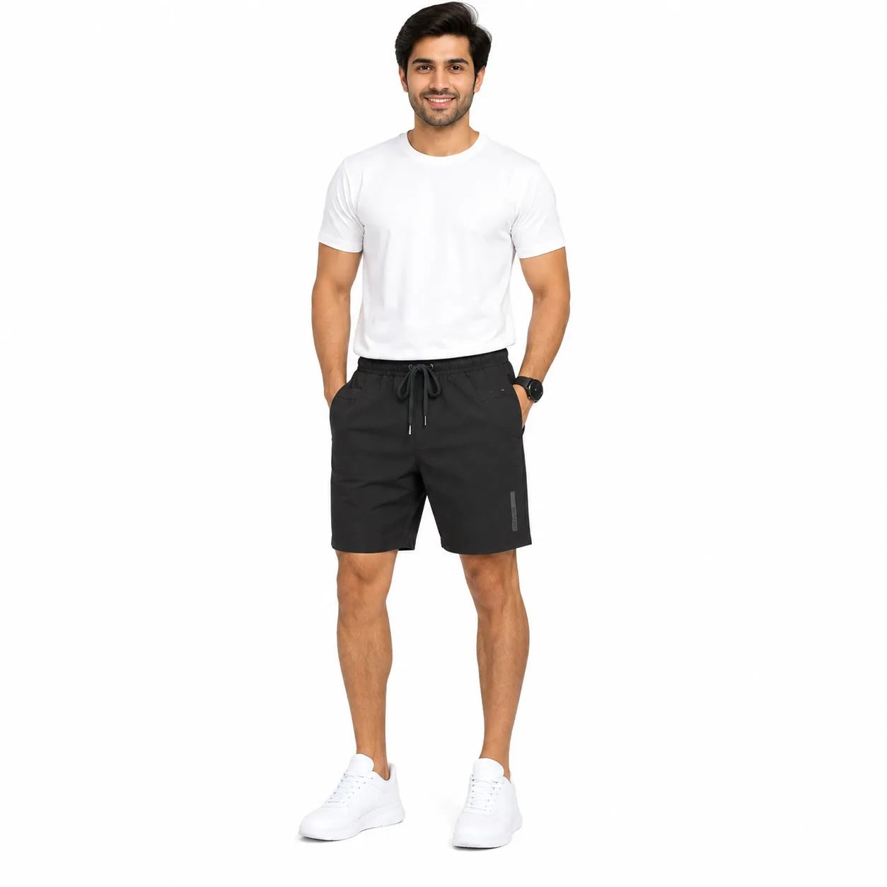 A man modeling black athletic shorts with a drawstring waist, paired with a white t-shirt and white sneakers, standing against a plain white background.