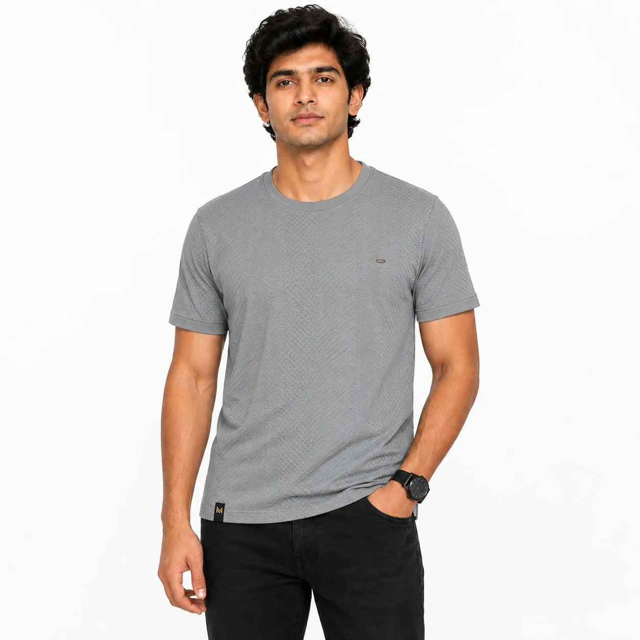 A man wearing a textured gray crew-neck t-shirt and black pants, standing against a plain white background.
