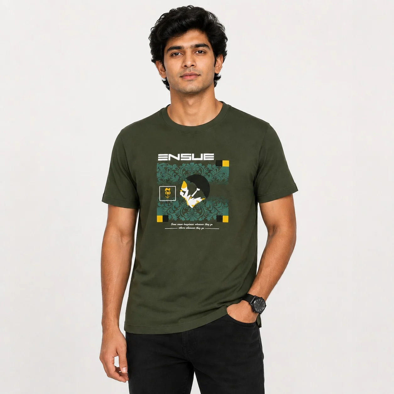 A man wearing an olive green crewneck t-shirt with a graphic print on the front. The graphic features the word 'ENSUE' in white above a stylized illustration with teal, yellow, and black details.