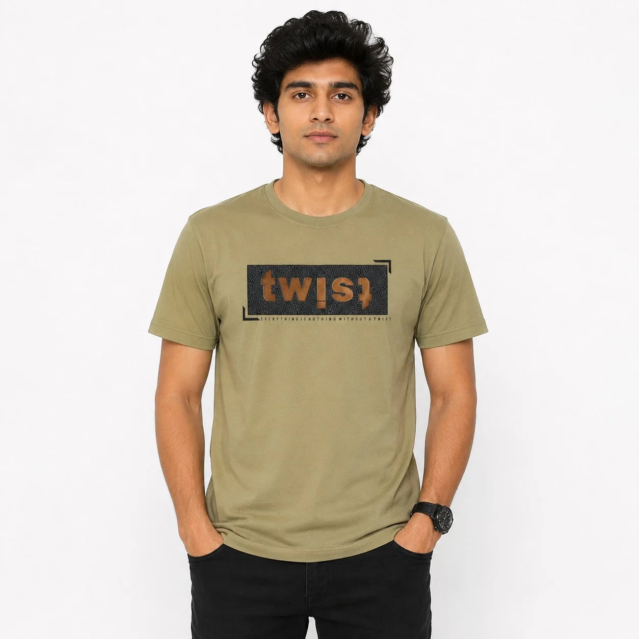 A man wearing an olive green crewneck t-shirt with a black graphic box on the chest containing the text 'twis1' in orange and white. The background is a clean white studio backdrop.