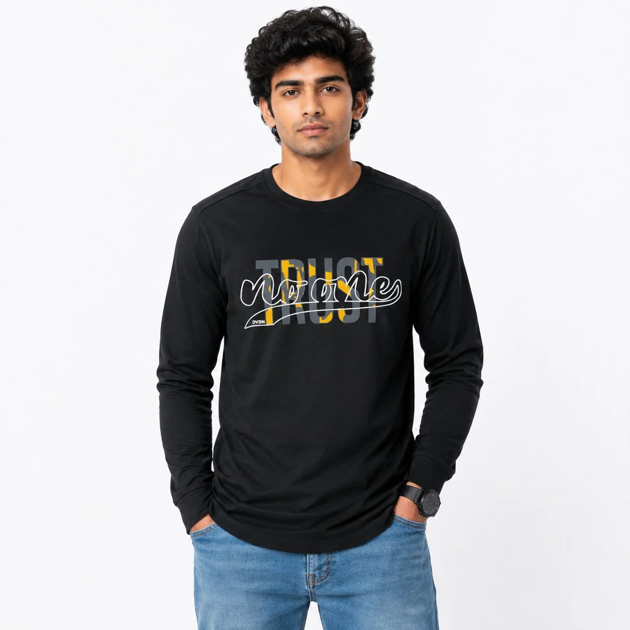 A man wearing a black long-sleeve t-shirt with a 'Trust No One' graphic in yellow, white, and gray, paired with blue jeans, against a plain white background.