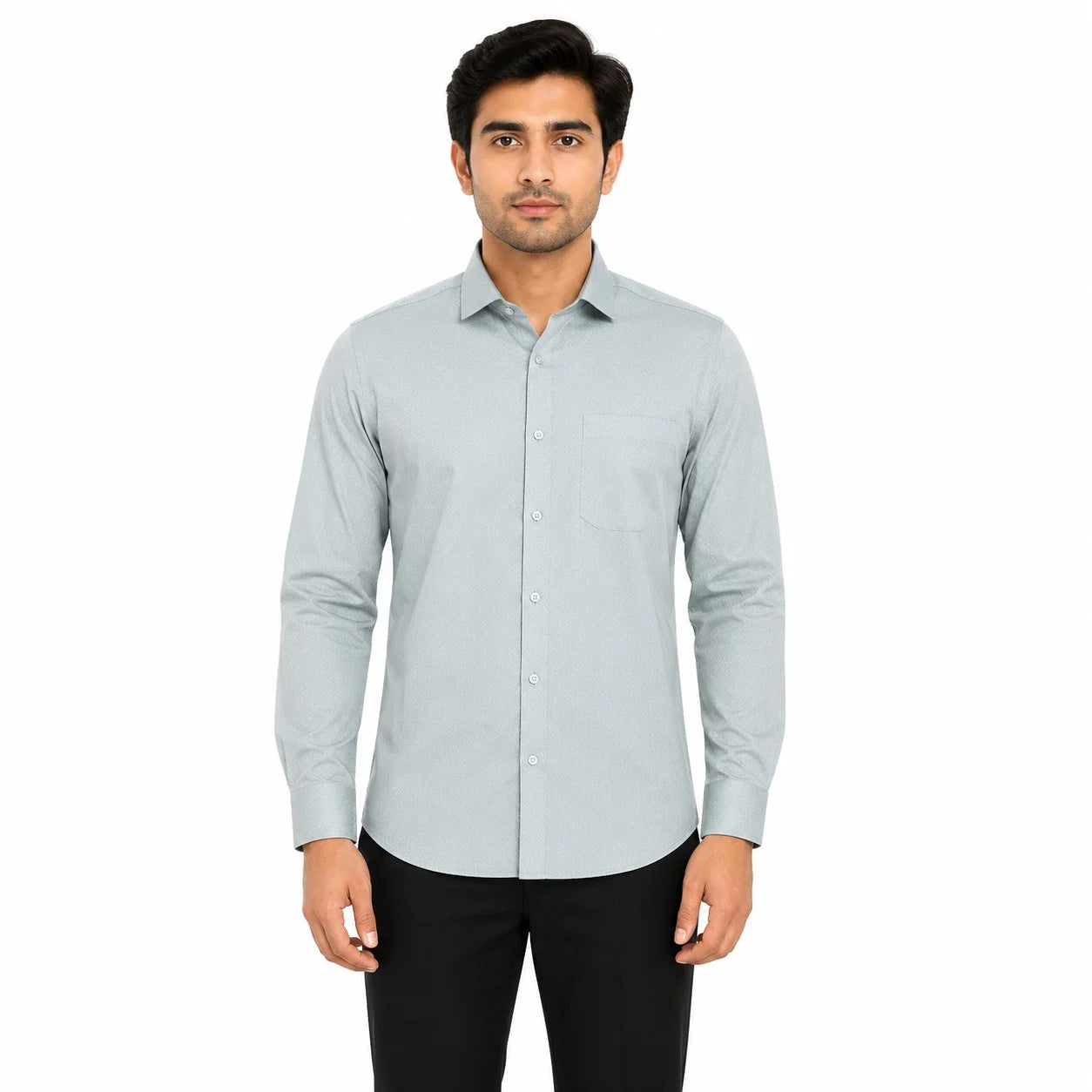 A man wearing a light gray long-sleeve button-down shirt with a single chest pocket, paired with black trousers, standing against a plain white background.