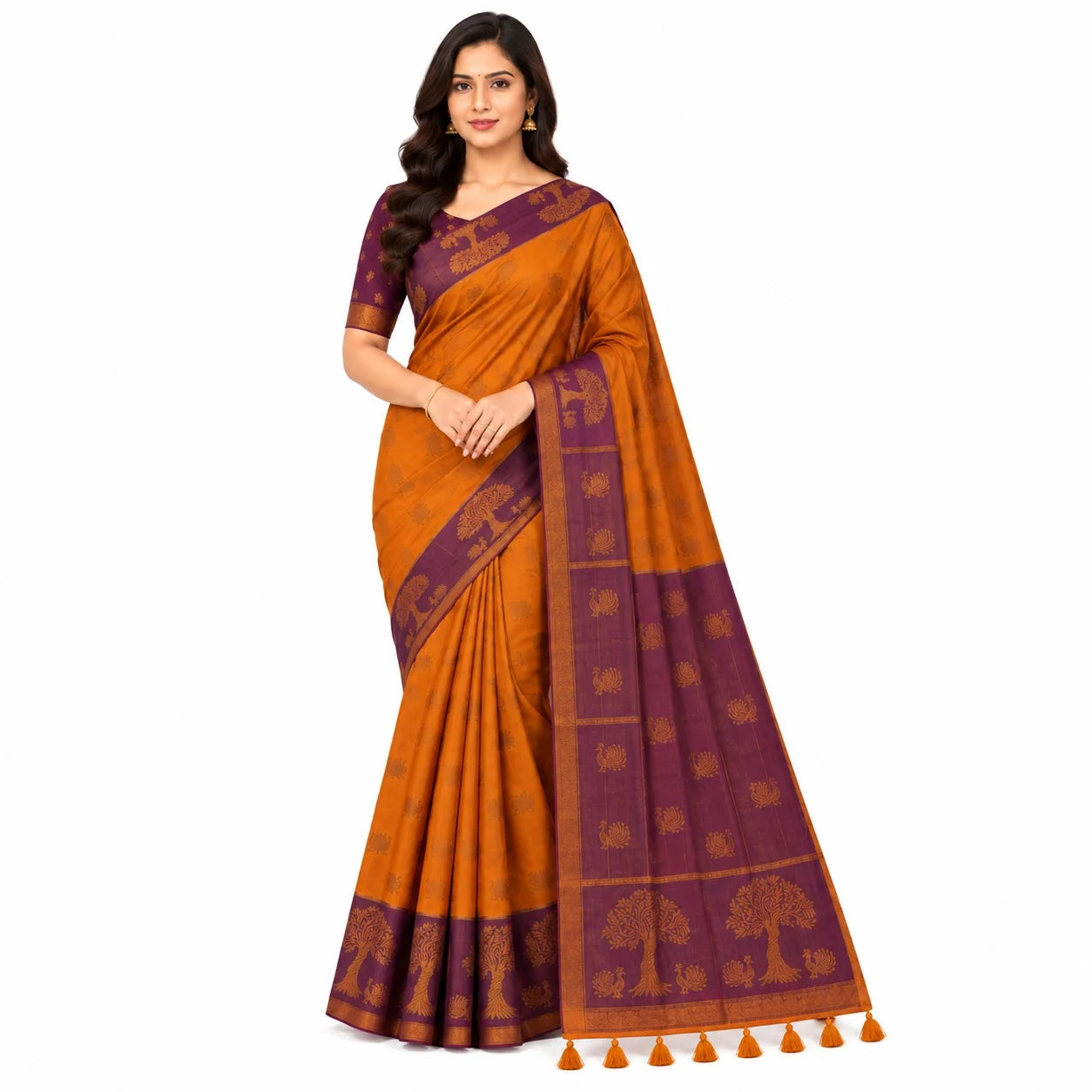 A woman modeling a traditional Indian saree with a warm orange body and deep purple borders, featuring woven motifs and a tassel border, set against a plain white background.